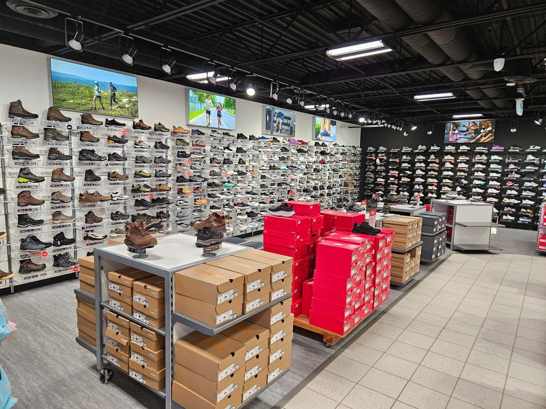 A long wall of hiking, running and lifestyle shoes